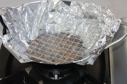 中華鍋に火をかけて燻製チップを炙る